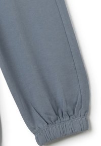 Grijze katoenen joggingsbroeken met elastische boorden, een gladde textuur en een taps toelopend ontwerp. Stiksel details omlijnen het been.