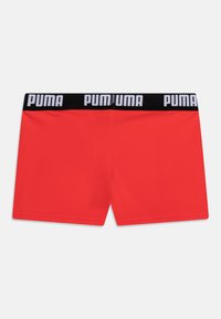 Boxer in rosso realizzati in tessuto morbido, dotati di una vita elastica nera con il logo "PUMA" in bianco. Design semplice e moderno.
