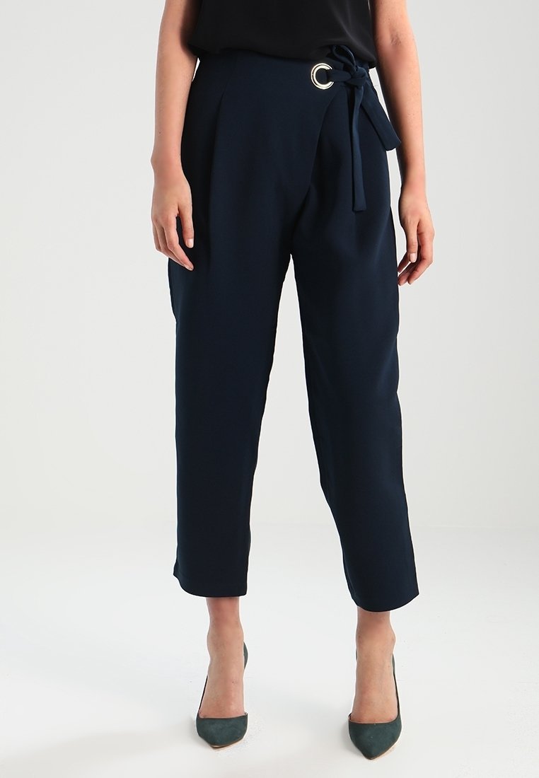 Granatowe spodnie o wysokim stanie o gładkiej fakturze, z szerokimi pętlami na pasek i przewiązanym paskiem z materiału. Otwarty dół i prosty krój.
