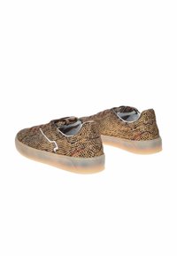 Sneaker con una toma superiore marrone e testurizzata, caratterizzata da borchie dorate, un accento bianco lungo il lato e una suola in gomma traslucida.