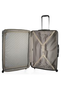 Maleta dura negra abierta, mostrando un interior gris con un bolsillo con cremallera y correas cruzadas. Cuenta con un mango telescópico y cuatro ruedas.