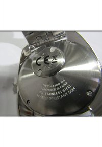 Le fond en acier inoxydable de la montre présente un texte gravé, indiquant un assemblage en Chine et une résistance à l'eau jusqu'à 50 mètres.