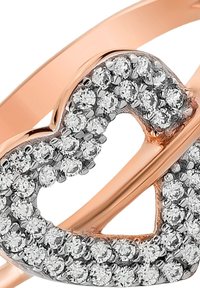 Bague en or rose avec un design en forme de cœur, ornée de multiples pierres de zirconium cubique claires, avec des textures métalliques lisses et polies.