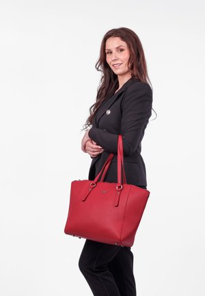 Červená kožená kabelka na rameno se dvěma horními ušima, čtvercového tvaru, s prošíváním a stříbrným kováním. Disponuje texturovaným povrchem.