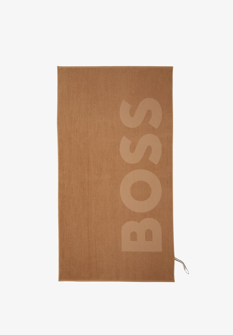 Serviette rectangulaire marron avec de grandes lettres verticales "BOSS" en relief sur le côté droit et une petite boucle rayée dans le coin inférieur.