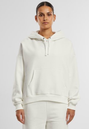 White cotton hoodie with a front pocket, drawstring closure, and ribbed cuffs. Features a subtle logo on the chest and a relaxed fit.