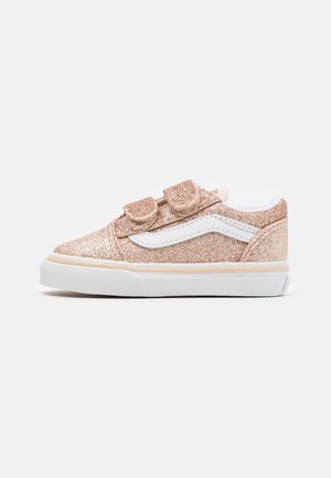 Børnesneaker med lavt snit i rosaguld glittersfinish, hvid sidestribe, dobbelt velcrorem og hvid gummisål på ensfarvet baggrund.