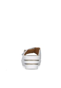 Zapato blanco de tipo slip-on con puntera redondeada, tacón bajo y acentos de línea dorada. Textura suave y forro interior blando para mayor comodidad.
