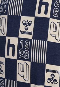 Marineblauw en crème patroon stof met cijfers, strepen en het "hummel" logo, met een zachte, textuurachtige uitstraling.