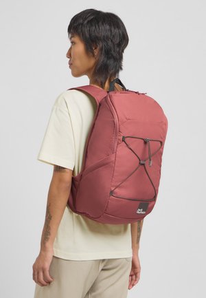 Bordeauxrode rugzak met een gestructureerde buitenkant, verstelbare bandjes en een elastisch koorddetail. Heeft een opvallend logo aan de onderkant aan de voorkant.