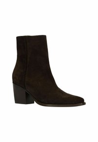 Bruine suède enkelboot met een puntige neus en blokhak. Kenmerkt zich door tonale stiksel en een hoge schacht die voorbij de enkel reikt.