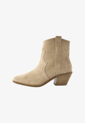 Beige suède enkelboot met een spitse neus, geschulpte vorm, een trekhaak en een gestapelde hak, met een getextureerde zool voor grip.