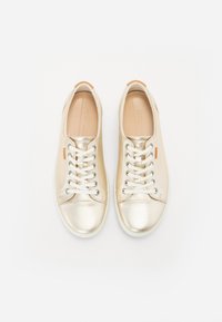 Metallic gold sneakers with white laces, smooth texture, rounded toe, and contrasting back tab detail; flat rubber soles.