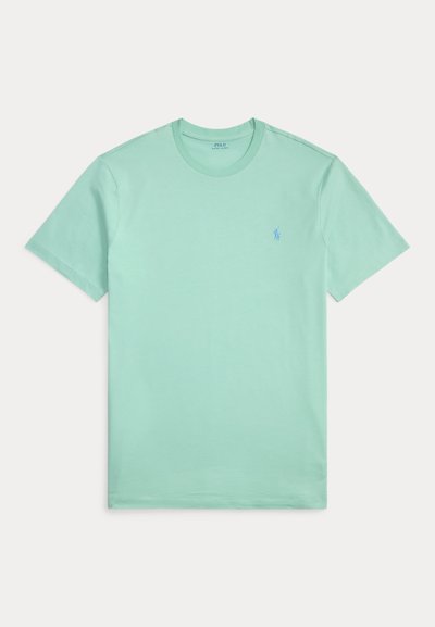 Ανοιχτό πράσινο βαμβακερό μπλουζάκι με στρογγυλή λαιμόκοψη και κοντά μανίκια· διαθέτει μικρό μπλε κεντημένο λογότυπο στο αριστερό στήθος.