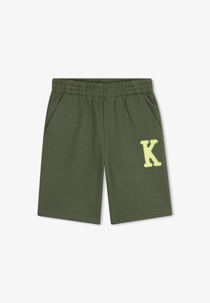 Shorts en coton vert avec une taille élastique, deux poches latérales, et un appliqué jaune clair en forme de "K" à l’avant. Texture lisse, design décontracté.
