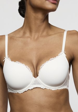 Witte beha met kanten rand, gevoerde cups, beugelondersteuning, verstelbare bandjes en strikdetails op de schouderbandjes en in het midden.
