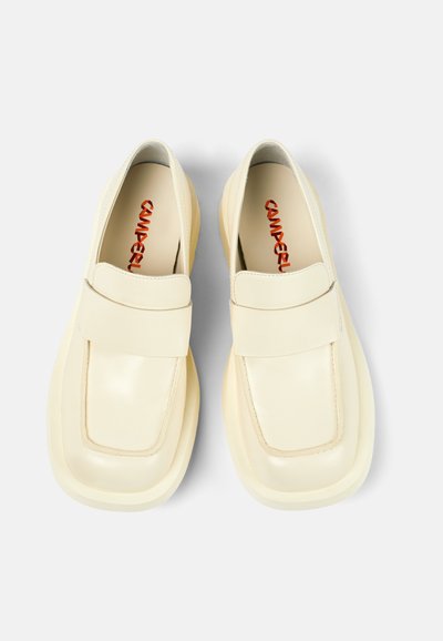 Krämfärgade läderloafers med bred rem och rund tå. Slät textur, vadderade sulor och kontrasterande röd varumärkeslogotyp inuti.