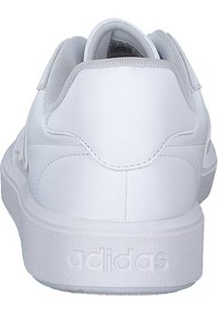 Witte sportieve schoenen met een gladleren bovenwerk, gewatteerde kraag en een gestructureerde rubberen zool. Heeft een reliëfmerk op de hiel.