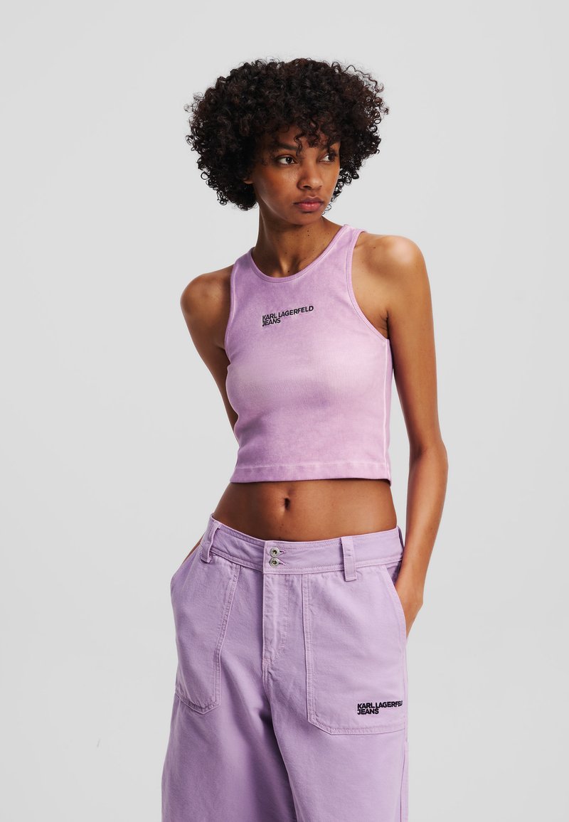 Heled lilla lühike tank top, millel on ribakirjaga tekstuur ja ümar kaelus, millel on must "KARL LAGERFELD JEANS" logo. Koos sobivate pükstega.