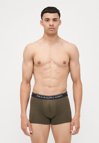Rudos medvilnės boxer tipo šortai su juodu juosteliu, ant kurio yra "POLO RALPH LAUREN" logotipas, prigludusio dizaino ir vidutinio aukščio.