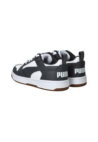 Zwart-witte sneakers met een gestructureerde leren bovenkant, vetersluiting, gepolsterde kraag en een rubberen zool. Witte "PUMA" branding op de hiel.