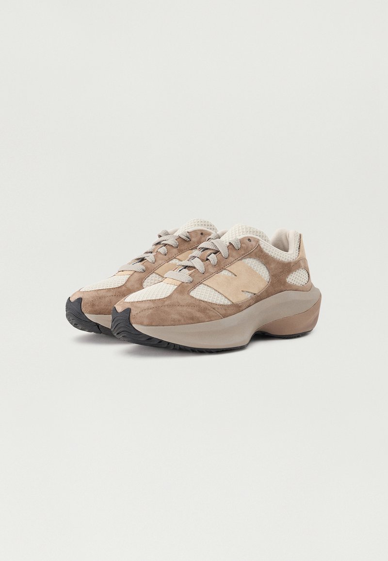 Sneaker leggere con una combinazione di suede color beige e mesh. Presentano lacci grigi, suola in gomma arrotondata e pannelli laterali in mesh per una migliore traspirabilità.