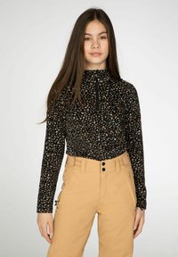 Zwarte fleece top met hoge kraag en halve rits met een gespikkeld patroon, gecombineerd met beige broeken met knoop- en ritssluiting.