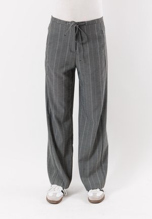 Pantaloni a righe grigie con una vestibilità larga, dotati di vita con coulisse. Realizzati in un materiale leggero, hanno una texture uniforme e gambe dritte.