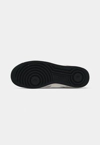 Fekete gumi talp koncentrikus körkörös mintázattal és texturált felülettel. Világosszürke alap, finom foltokkal. Szabványos sneaker forma.