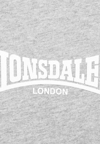Sivi dukserica mekane teksture s podebljanim bijelim natpisom "LONSDALE" koji se uzdiže iznad "LONDON" u centru.