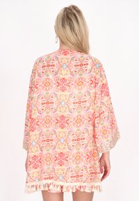 Kerge kimono, millel on erksad oranži, roosa ja sinise mustrid; omab laiad varrukad ja keerukat pitsi ääret. 