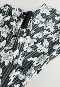 Black and gray pants with white ghost patterns and text saying "BOO" and "I AIN'T AFRAID OF NO" in a repeating design.
