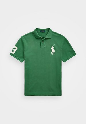 Zelena polo majica iz bombaža, z dvema gumboma, kratkimi rokavi in belim vezenim logotipom na levi strani in na rokavu.