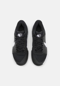 Black athletic shoes with a textured mesh upper, contrasting white accents, and a sturdy rubber sole. Features traditional lacing system.