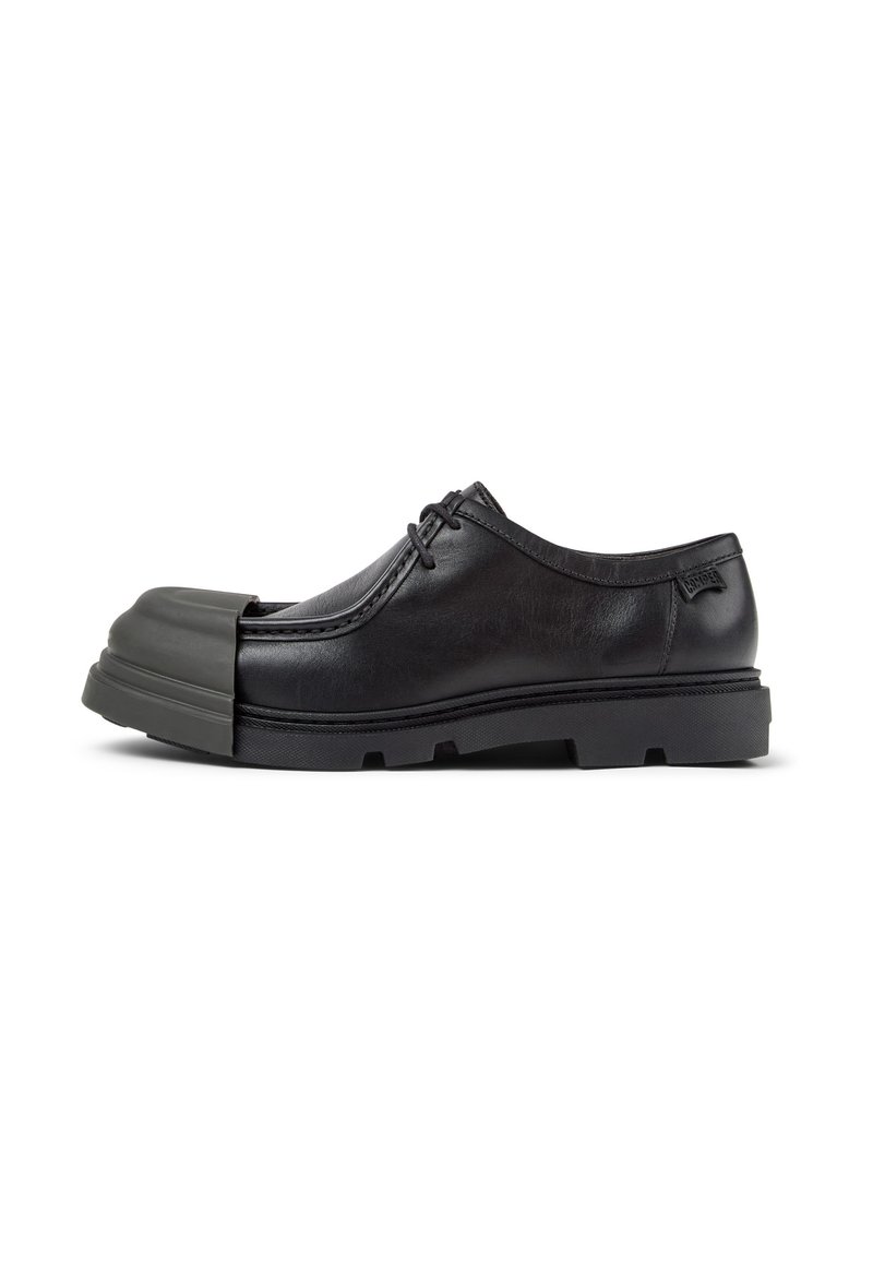 Scarpa in pelle nera con punta arrotondata e un cappuccio in gomma grigia. Include un design stringato e suola testurizzata per una migliore aderenza.