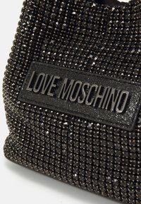 Fekete gyöngyös kézitáska, texturált felülettel, fémes kiegészítőkkel és egy téglalap alakú címkével, amelyen a "LOVE MOSCHINO" felirat található.