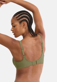 Oliwkowy biustonosz wykonany z gładkiej tkaniny, wyposażony w regulowane ramiączka i zapięcie na haftkę. Charakteryzuje się eleganckim, minimalistycznym wzornictwem.