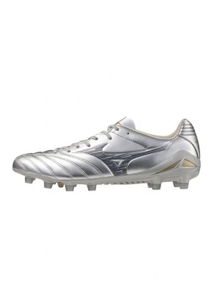 Scarpa da calcio argento con tacchetti modellati, lacci e dettagli cuciti, che mostra un profilo laterale rivolto verso destra su sfondo bianco.