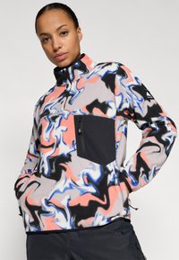Flanellpullover abstraktse keerismustriga, roosa, sinise ja musta värvi. Omab musta tõmblukuga rinnaeperi ja kõrget kraed.