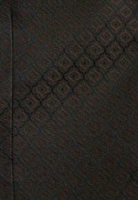 Stoff mit einem komplexen Diamantenmuster in dunklen Braun- und Schwarztönen, der eine strukturierte Oberfläche mit subtilen Glanz und Tiefe zeigt.