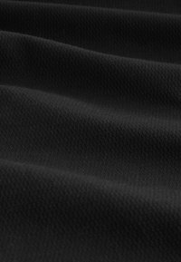 Czarna tkanina o textured powierzchni, z miękkimi falami i subtelnymi wzorami. Materiał wydaje się trwały i wszechstronny w różnych zastosowaniach.
