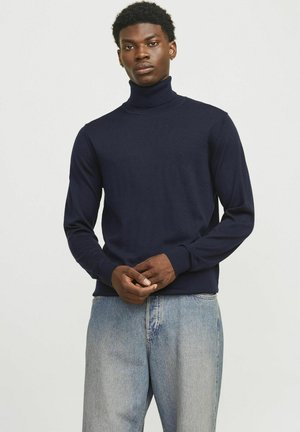Marineblå turtleneck sweater lavet af blødt strikstof, med lange ærmer, en tætsiddende hals og subtile ribbede detaljer ved manchetter og kant.