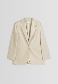 Beżowa marynarka wykonana z gładkiej tkaniny, z wyciętymi klapami, pojedynczym zapięciem na guzik, dwoma przednimi kieszeniami oraz luźnym krojem.