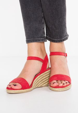 Punaiset mokkanahkaiset kiilakorkosandaalit espadrillityylisellä juutti-pohjalla, joissa on ristikkäiset remmit ja nilkkaremmi tukevan istuvuuden takaamiseksi.