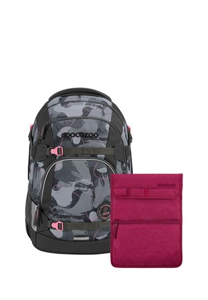 Black and gray camo-patterned backpack with pink accents next to a plain magenta pouch with zipper and flap closure, both branded Coocazoo.
