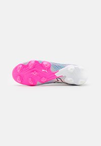 Sole di scarpa sportiva Puma con un motivo rosa e bianco, con tacchetti stampati, una superficie testurizzata e un design leggero.