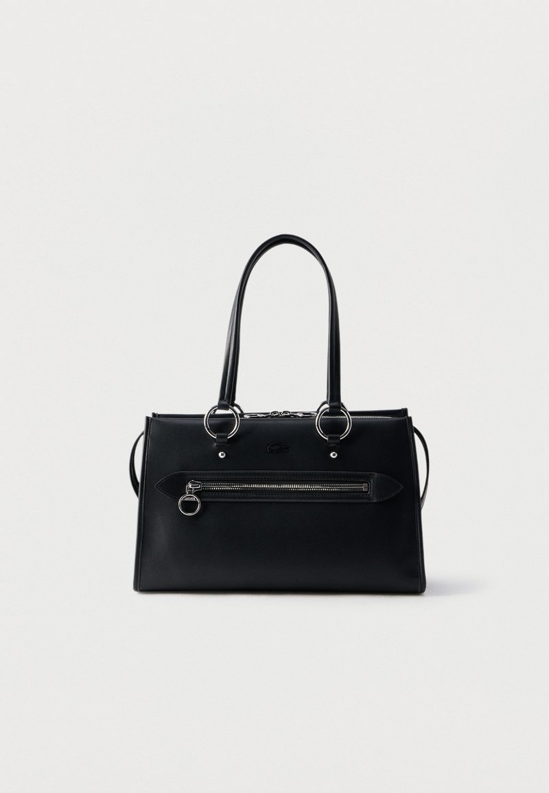 Μαύρη ορθογώνια δερμάτινη τσάντα χειρός με διπλές επάνω λαβές, εμπρόσθια τσέπη με φερμουάρ και δαχτυλίδι στο φερμουάρ, καθώς και διακριτικό ανάγλυφο λογότυπο πάνω από την τσέπη.