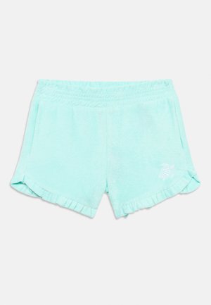 Ανοιχτό μπλε σορτς από πετσέτα με ελαστική μέση, πλαϊνές τσέπες, βολάν στο τελείωμα και μικρό κεντητό λογότυπο χελώνας στο αριστερό πόδι.