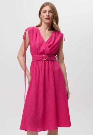 Vestido envolvente rosa con un acabado texturizado, mangas cortas, un cinturón atado con una hebilla circular dorada y una falda acampanada.