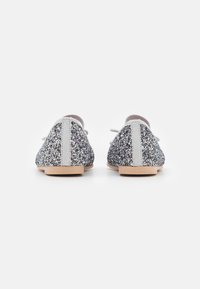 Ballerine glitterate in argento e multicolore con una texture liscia, un tacco posteriore di colore chiaro e lacci sottili e leggeri per la chiusura.